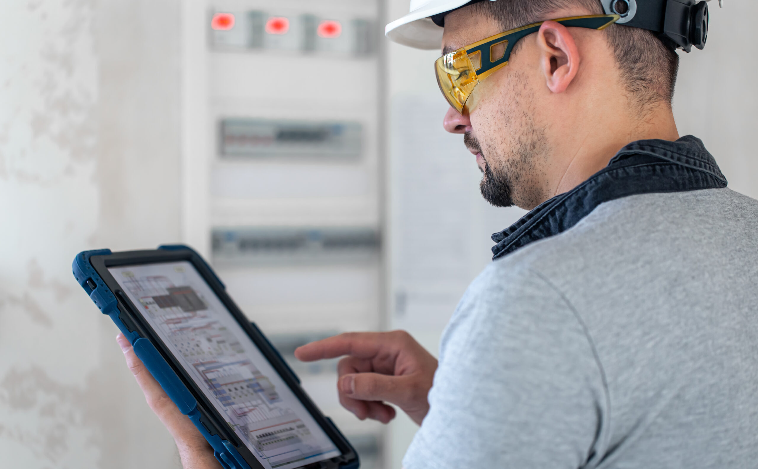electrical technician looking focused while working in a switchboard with fuses.